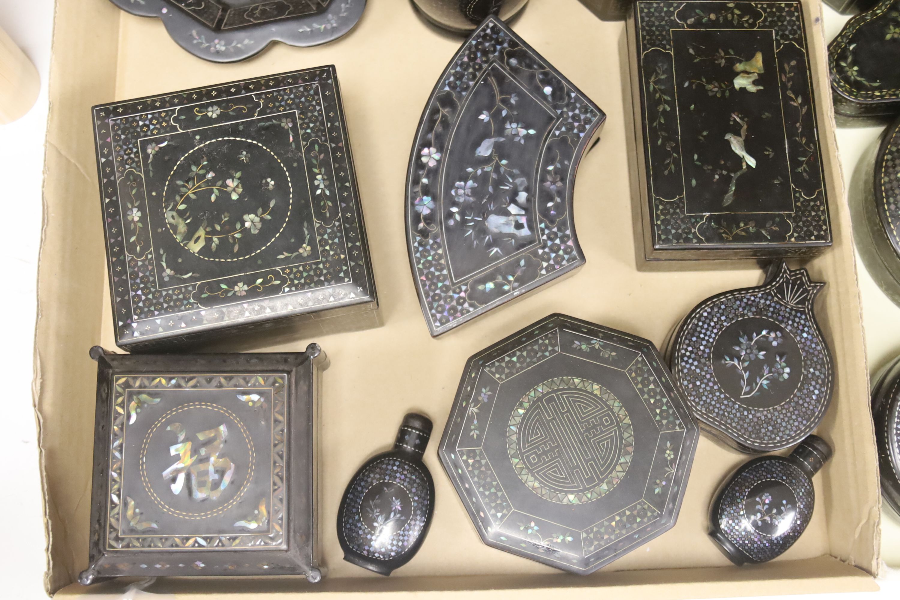 A quantity of Lac Burgaute boxes, inlaid with mother of pearl, largest 13cm diameter 10cm high (26)